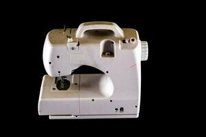 a white sewing machine on a black background photo