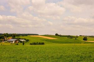 un granja en el campo con un verde campo foto