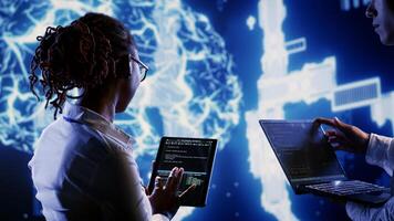 Engineering colleagues develop artificial intelligence neural networks architecture inspired by human brain, setting up AI machine learning algorithms using programming script on tablet photo