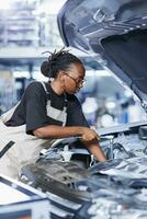 Repair shop technician examines defective car battery using advanced mechanical tools, ensuring peak automotive performance. Diligent worker in garage workplace conducts routine vehicle checkup photo