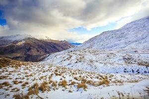 snow mountain and  crown range road  between wanaka town - queenstown new zealand photo