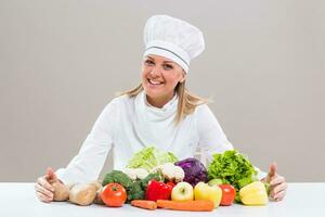 Beautiful chef showing bunch of vegetable photo