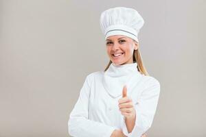 Portrait of beautiful female chef showing thumb up on gray background. photo