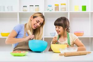 Happy mother and her daughter are making cookie together. photo