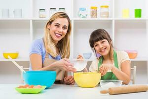 Happy mother and her daughter are making cookie together. photo