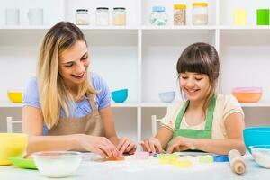 Happy mother and her daughter are making cookie together. photo