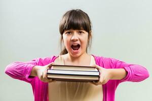 Angry little girl with books photo