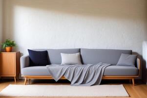 Fabric sofa with grey pillow and blanket against stucco wall. photo
