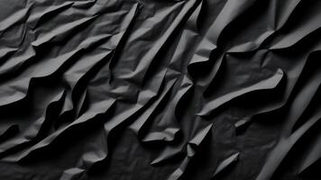 Heavy crumpled black paper texture in low light background. photo