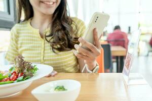 Woman use smartphone to scan QR code to pay in cafe restaurant with a digital payment without cash. Choose menu and order accumulate discount. E wallet, technology, pay online, credit card, bank app. photo