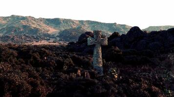A cemetery cross standing tall amidst a breathtaking mountain range video