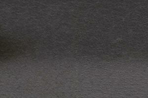 Dark gray background from natural slate. Texture of stone closeup. Graphite background macro photo
