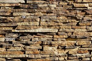Background of stone wall texture. The surface of the stones is brown photo
