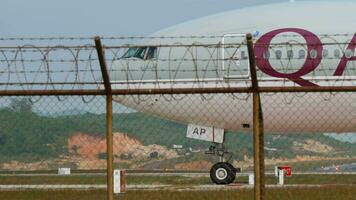 Phuket, Thaïlande janvier 31, 2023 corps large passager Boeing 777 de Qatar compagnies aériennes roulage à phuket aéroport. tourisme et Voyage concept. avion roulage, côté vue video