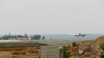 Phuket, Thailand Januar 29, 2023 aeroflot Landung und berühren, Bremsung beim Phuket Flughafen. Landebahn in der Nähe von das Meer Küste. Jet von Luftasien warten im Linie zum Abfahrt video