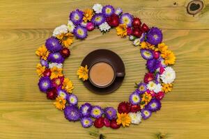 Image of cup of coffee with beautiful flowers on wooden background photo