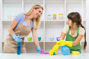 Happy mother and her daughter enjoy cleaning together. photo