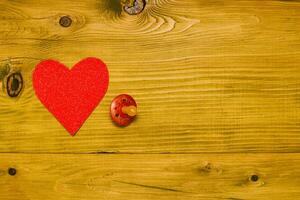 Pink heart on a wooden table with pacifier photo