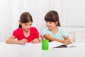 Cute little girls doing homework together photo