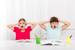 Little girls are in panic because of their homework. photo
