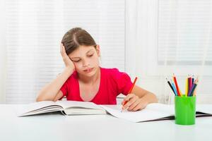 Little girl must stay at home and do her homework,but she would rather play outside. photo