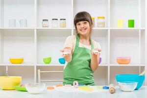 Happy little girl enjoys making cookie photo