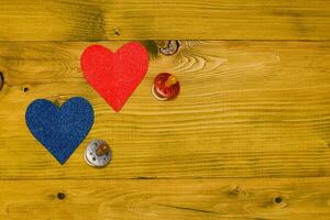 Two hearts on a wooden table with pacifier photo