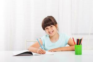 Cute little girl is doing her homework photo