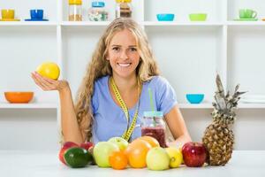 hermosa niña es demostración limón y Fruta batido, eso es su receta para sano peso pérdida. foto