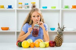 Beautiful girl enjoys drinking smoothie at her home photo