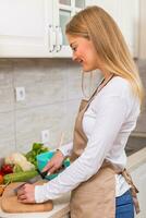 Beautiful woman making meal in her kitchen photo