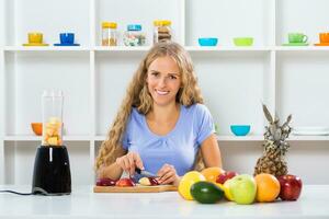 Beautiful girl enjoys making smoothie at her home photo