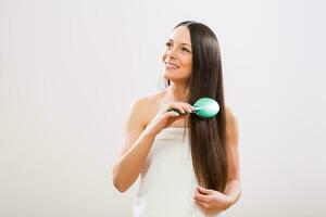 Cheerful woman brushing her beautiful long hair photo