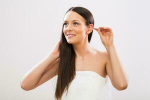 Image of beautiful brunette woman cleaning ears photo