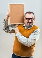 Nerdy businessman is showing empty cork board photo