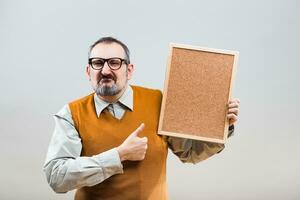 Nerdy businessman is showing empty cork board photo