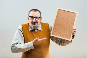 Nerdy businessman is showing empty cork board photo