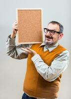 Nerdy businessman is showing empty cork board photo