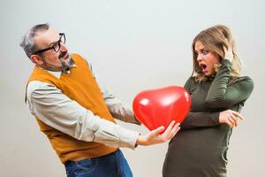 Nerdy man wants to give heart shape balloon to a beautiful woman to show her his love,but she is not interested,she is terrified. photo