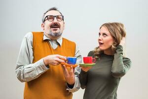 Funny nerdy man and beautiful woman enjoy drinking coffee photo