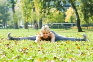 hermosa mujer hacer ejercicio yoga al aire libre foto