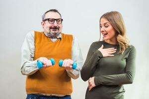 Nerdy man is flexing muscle to show a beautiful woman how strong he is and she is impressed photo