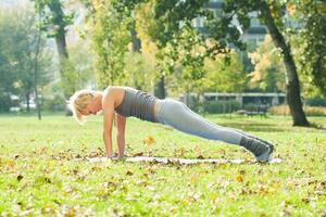 hermosa mujer hacer ejercicio yoga al aire libre foto