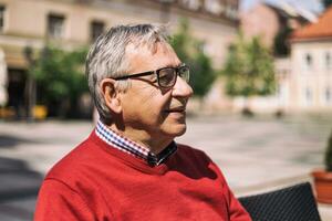 Cheerful senior man enjoys sitting at the bar photo