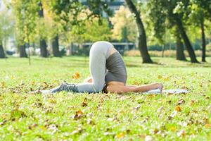 hermosa mujer hacer ejercicio yoga al aire libre foto