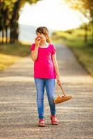 Beautiful little girl enjoys eating apple while walking in the nature photo