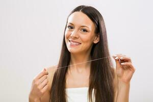 Image of beautiful brunette woman showing dental floss photo
