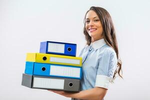 Portrait of happy businesswoman holding office archives on gray background photo