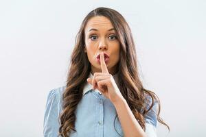 Beautiful businesswoman showing silence sign on gray background photo