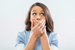 Businesswoman covering her mouth on gray background photo